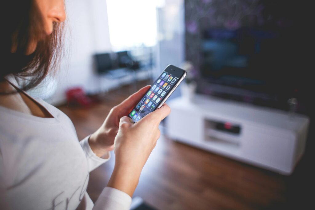 Frau, Die Weißes V Ausschnitt Hemd Mit Space Grey Iphone 6 Trägt